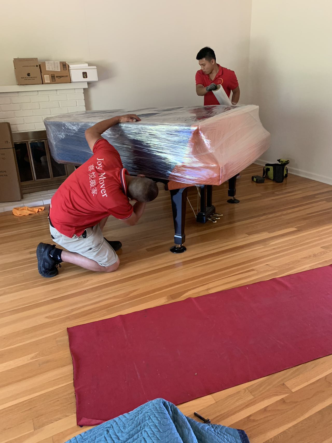 New Joy Moving mover wrapping furniture inside a home before transport